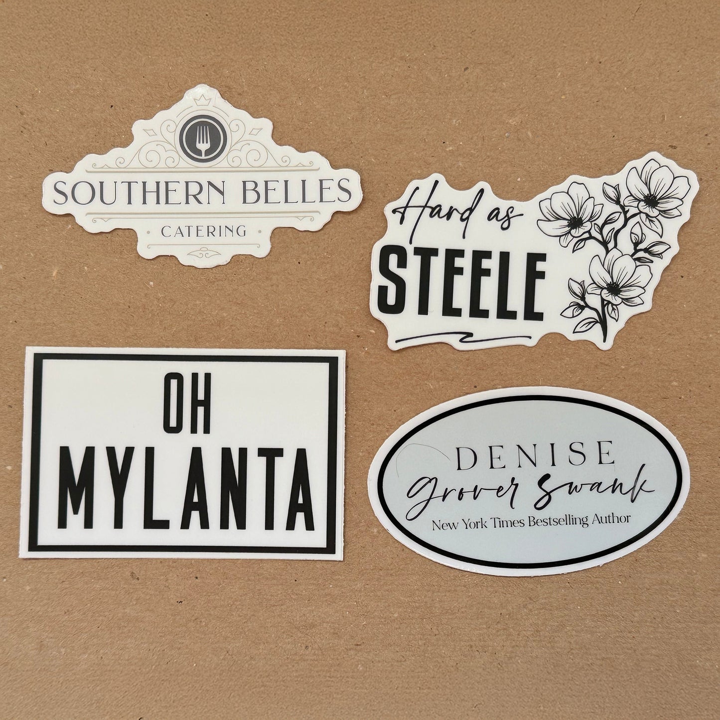 A set of four black and white stickers with various designs including 'Southern Belles Catering' and 'Hard as Steele'.